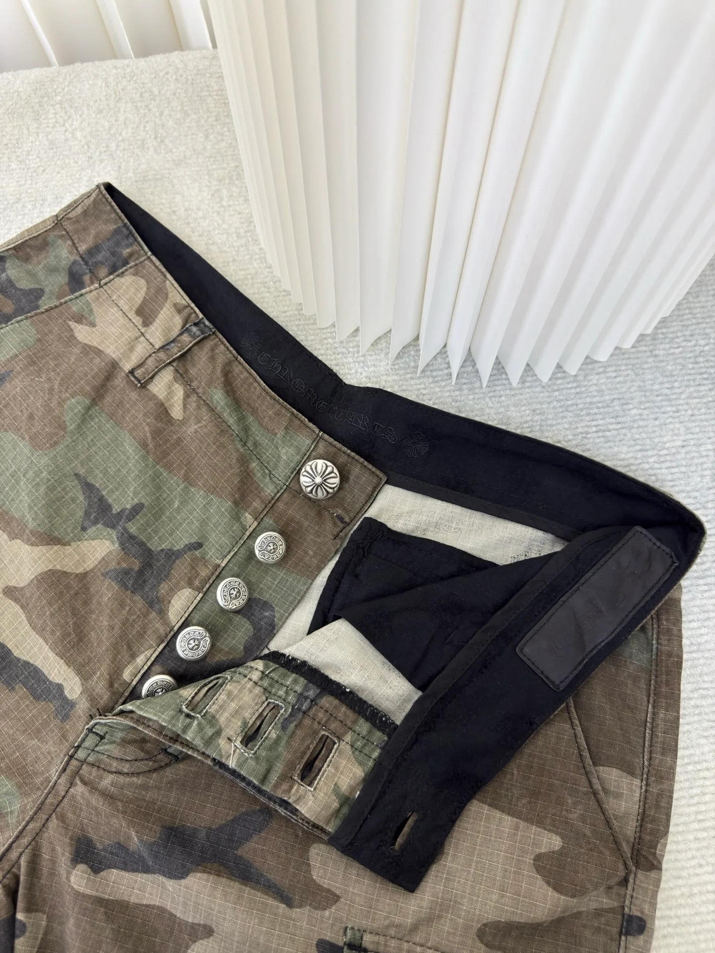 P610 Chrome Hearts camouflage leather and genuine antique silver overalls. The main fabric is dyed with fully divided camouflage. The lining is made of CH jacquard lining. The minimum order is 1000 meters. The whole pants have 14 genuine antique silver hardware. Half of the cost is in the hardware. The leather is made of imported lambskin. Hand-made edge stitching. The embroidery on the waist uses imported Tajima machine. Precision embroidery. Size 32/S 34/M 36/L